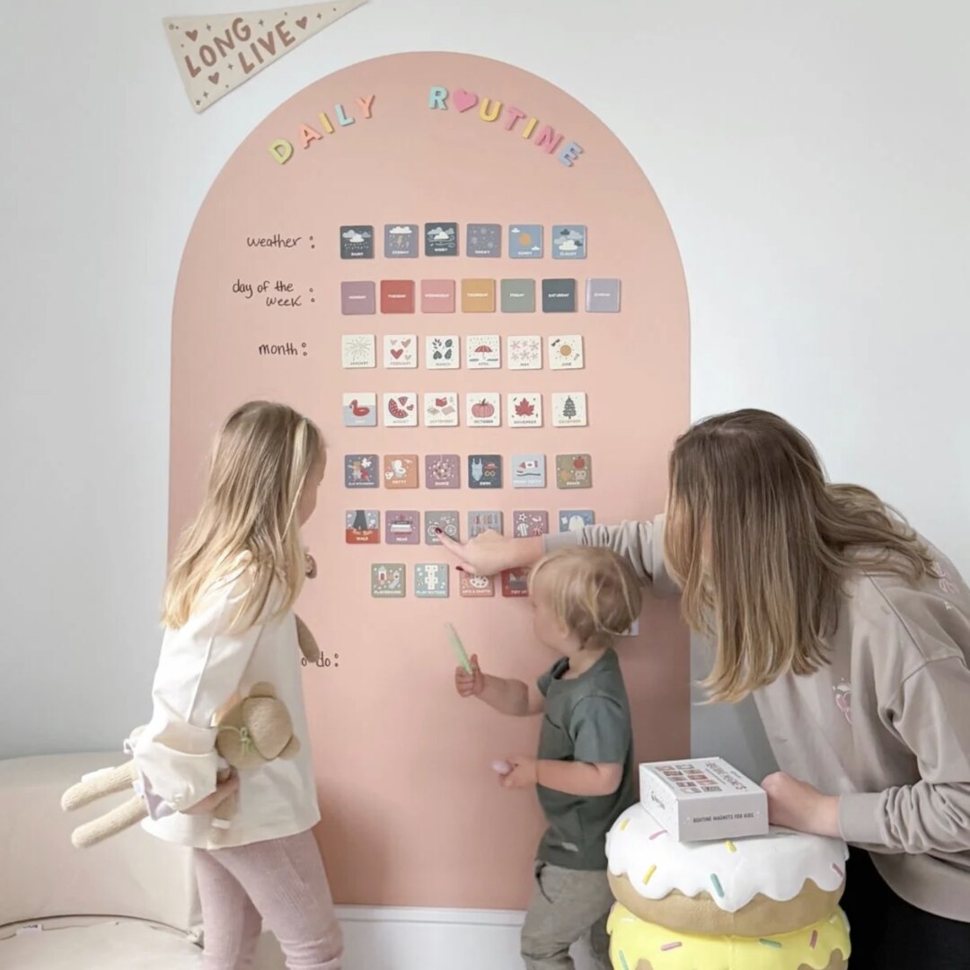 A mom and her two children building a daily-routine board with Cherrypick's magnetic products
